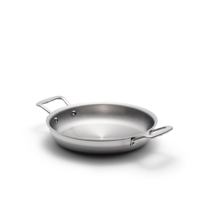 Angled overhead of 10-inch stainless steel fry pan with short loop handles and brushed interior on white background