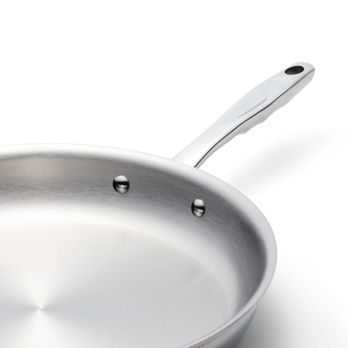 Stainless steel frying pan with long riveted handle on white background
