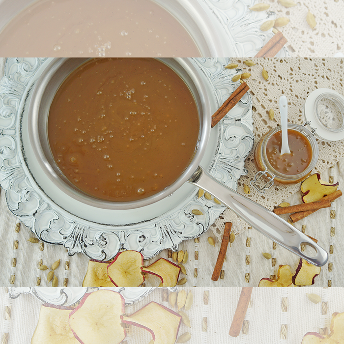 Top down view of 2 quart saucier showing rounded interior and wide mouth with caramel sauce, jar and cinnamon sticks on linen