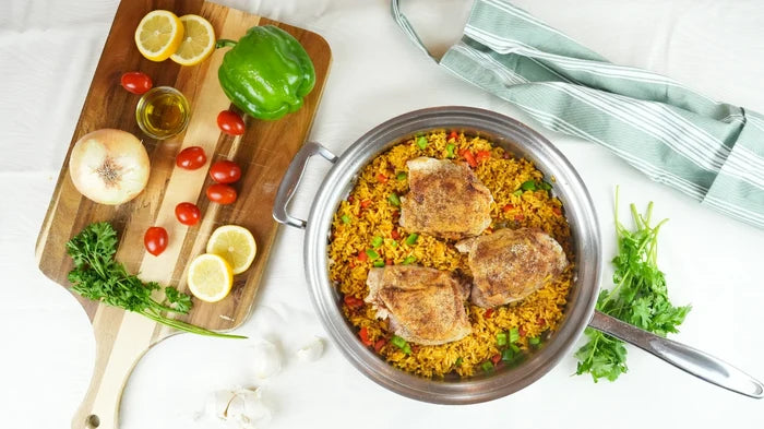 Overhead view of 3.5-quart stainless steel sauté pan (lid off) showing cooked rice and browned chicken on a white tabletop