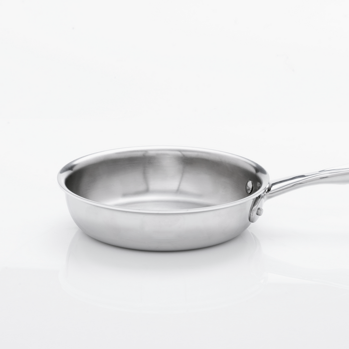 Angled side view of 7 Inch Fry Pan showcasing brushed stainless steel interior and riveted long handle on white background