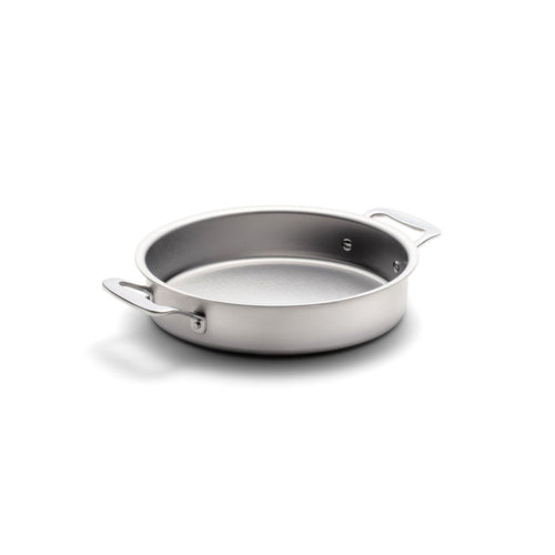 Angled view of 9 inch round cake pan with handles showcasing stainless steel construction on a white background