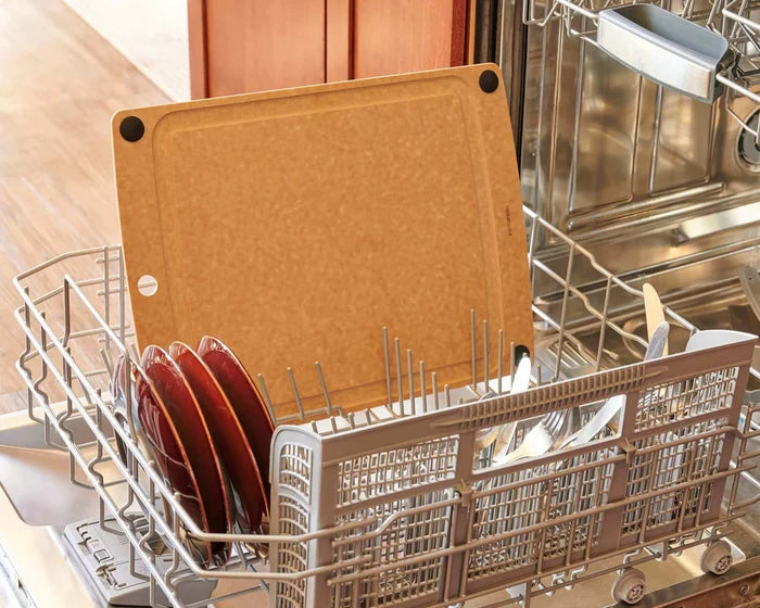 Top rack All-In-One Series Cutting Board showing juice groove and black non slip feet in dishwasher with red plates