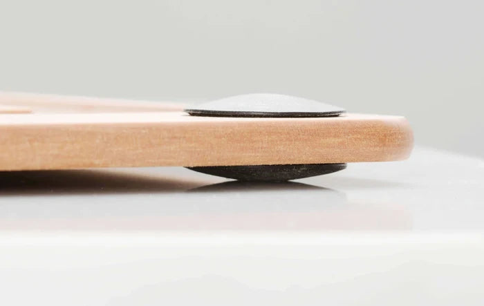 Close-up side view of All-In-One Series cutting board showing black non-slip silicone foot lifting the board off a light countertop