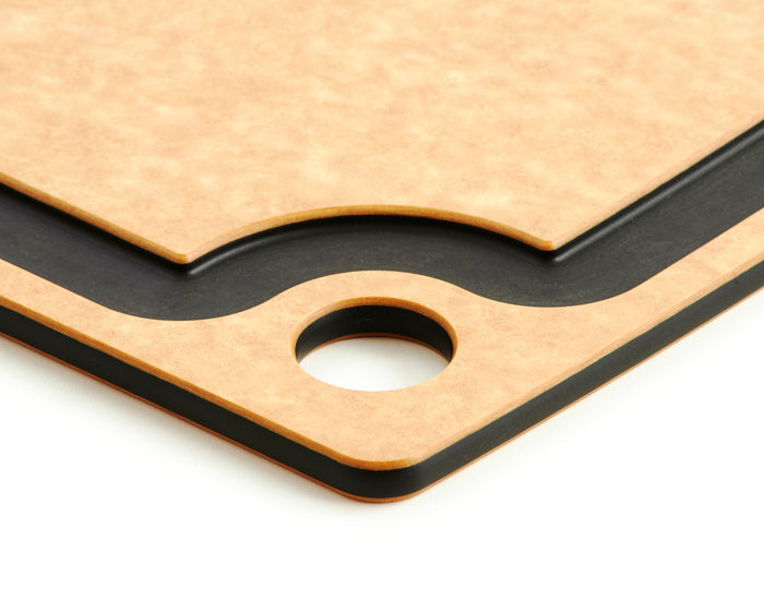 Close-up corner of All Natural Slate Cutting Board showing slate juice groove, layered profile and round hanging hole on white background