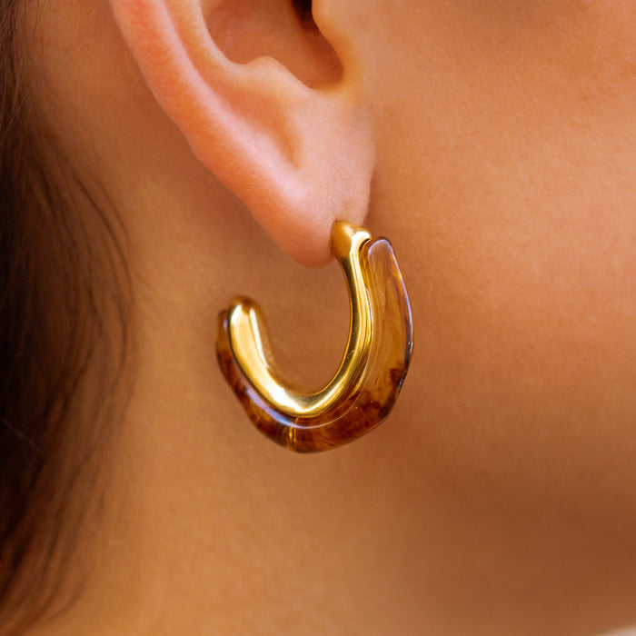 gold hoop earring featuring an amber resin hoop face on a person