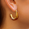 gold hoop earring featuring an amber resin hoop face on a person