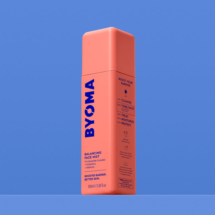 A BYOMA Balancing Face Mist bottle, angled view showing the "Boost Your Barrier" routine steps on the side panel, on a blue background.