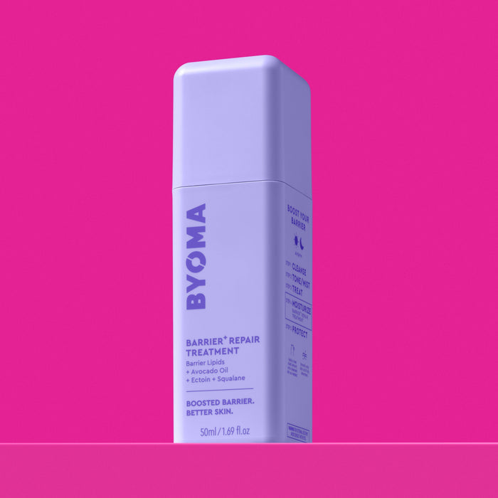 A bottle of BYOMA Barrier+ Repair Treatment, angled view showing the "Boost Your Barrier" routine steps on the side panel, on a pink background.