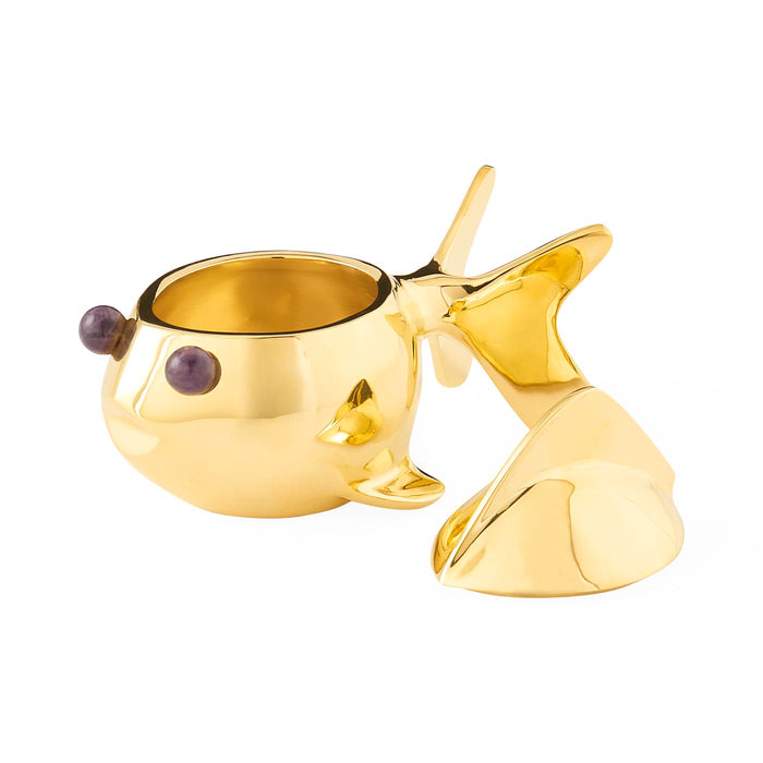 Gold whale-shaped candle holder on a white background