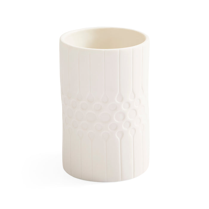 A white ceramic cup with a textured vertical ribbed pattern and a central honeycomb-like circular design, shown on a plain white background.