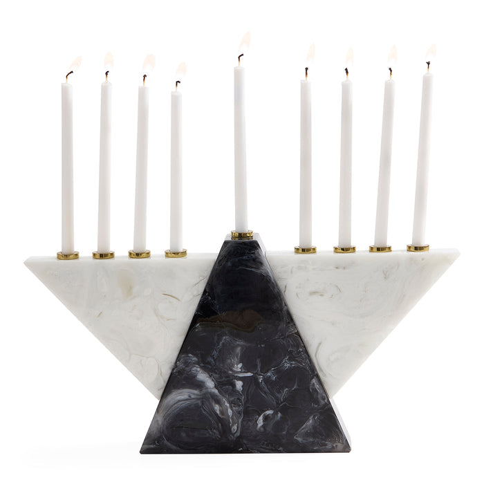 A three-tiered triangular Hanukkah menorah made of white and black marbled stone, holding nine white candles with gold-tone holders, set against a solid white background.