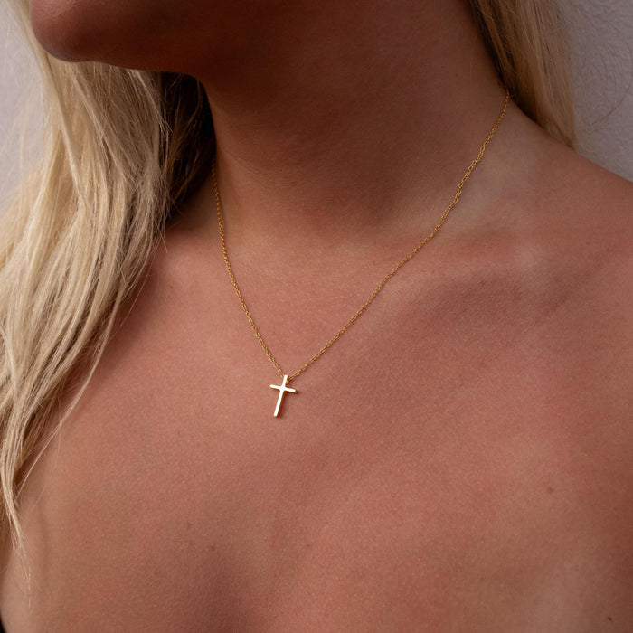 delicate necklace featuring a dainty chain and a simple gold cross