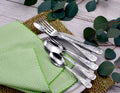 Top view of Earth flatware showing engraved handles on forks and spoons with green gingham napkin and eucalyptus