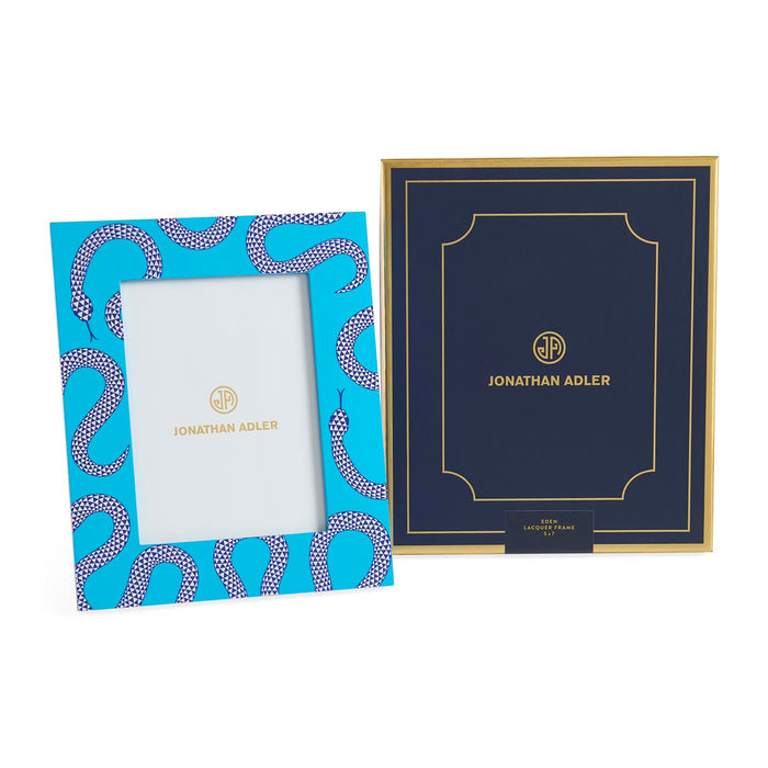Two Jonathan Adler picture frames, one blue with snake pattern and the other navy with gold border, on a white background.