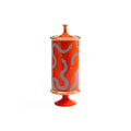 A tall cylindrical ceramic lidded jar or candle holder in bright orange-red, decorated with wavy dotted silver-gray patterns and accented with gold-toned trim at the top, bottom, and base.