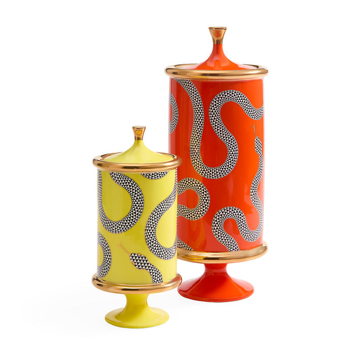 Two decorative ceramic pedestal jars with lids, one yellow and one orange-red, both featuring wavy dotted patterns and gold-toned rims, set against a plain white background.