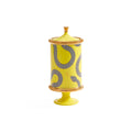A yellow ceramic decorative jar with a matching lid, featuring a black and white checkered snake pattern and gold-toned trim, set against a plain white background.