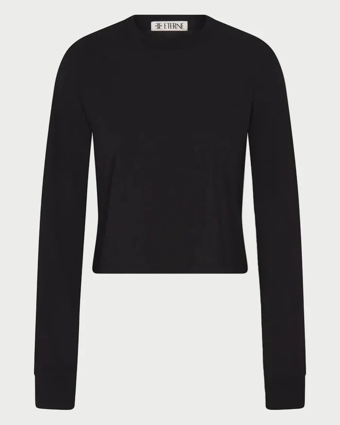 The Éterne Long Sleeve Boxy Tee by Eterne—a plain black, long-sleeve, crew neck sweater made from a cotton-modal blend—is displayed against a white background, with a small label visible at the neckline.