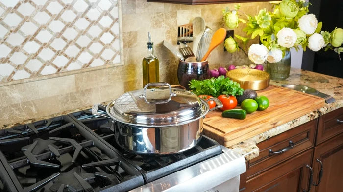 Angled view of 6-quart stainless steel stockpot with lid showing mirror finish and loop handles on a gas stove