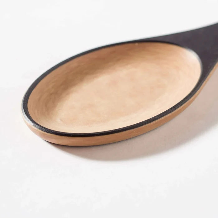 Close-up of Frank Lloyd Wright Large Spoon showing shallow light-wood bowl and thin black rim on white background