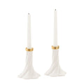 A pair of white taper candle holders with a flared, sculptural base and gold metallic bands near the top, shown on a plain white background.