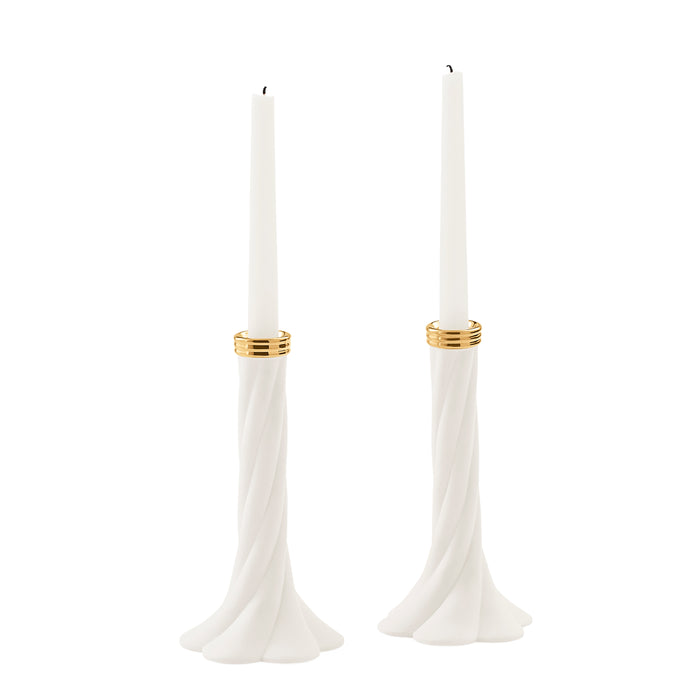 A pair of white taper candle holders with a twisted flared base and a thin gold band near the top, each holding a white taper candle, shown on a plain white background.