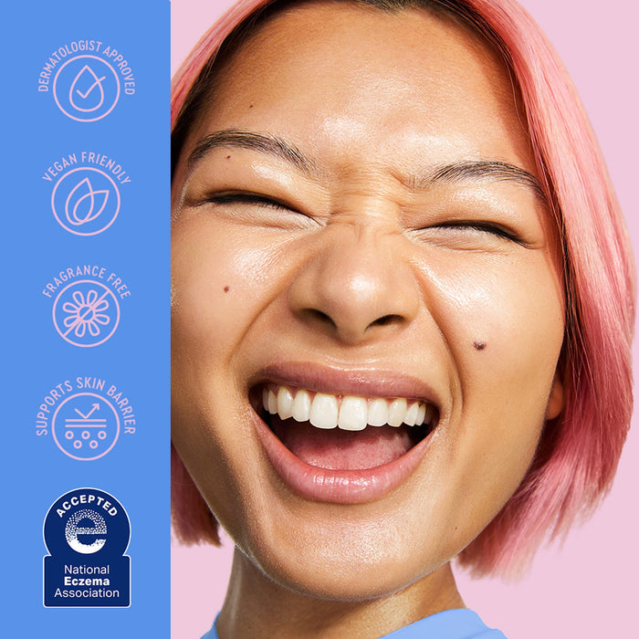 Close-up of a smiling woman with pink hair on a pink background, with a blue vertical panel on the left listing claims like dermatologist approved, vegan friendly, fragrance free, and supports skin barrier, plus an accepted eczema association badge.
