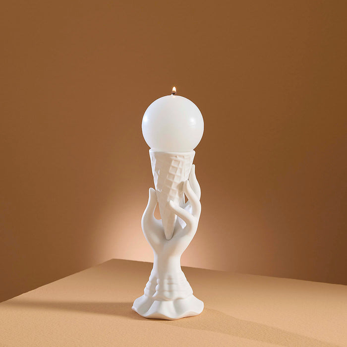 White ceramic sculpture of a hand holding a light bulb against a brown background