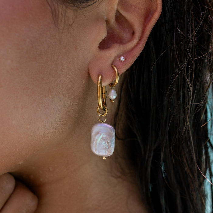 a resort inspired earring stack with large pearl hoops, dainty pearl huggies, and a dainty pearl stud