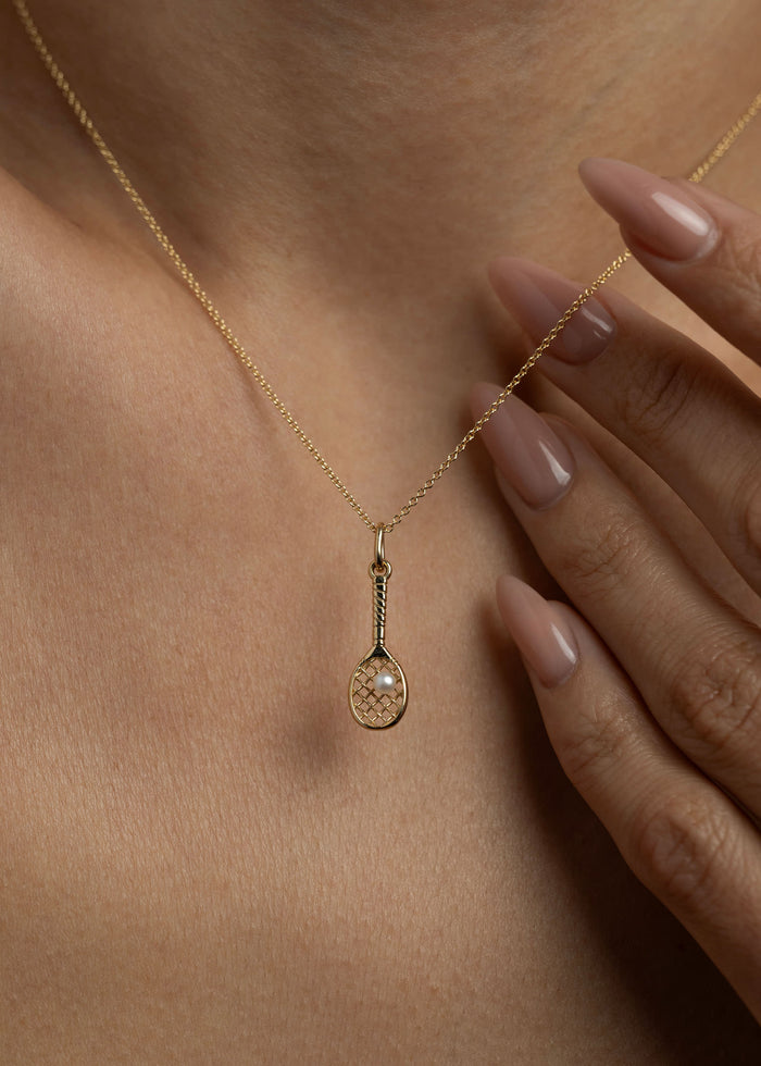 woman wearing a Kinn x Sunset Tennis Club 14k Gold Pearl Ball And Racquet Charm on a micro rolo chain necklace