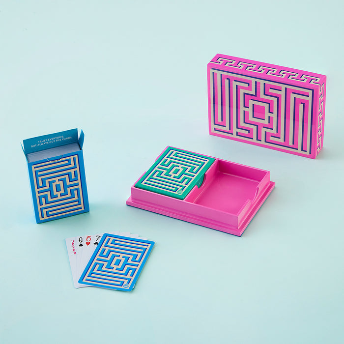 Colorful maze-themed card holder and playing cards on a light blue background