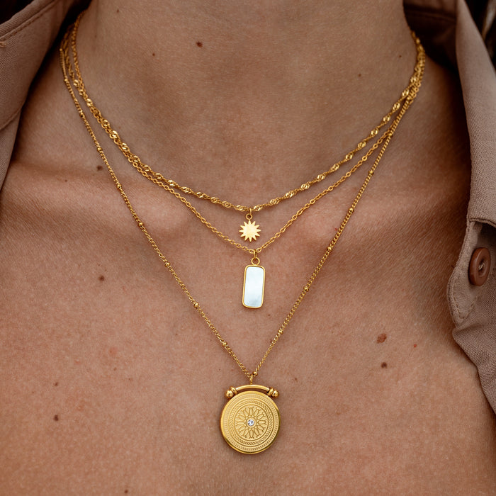 gold necklace stack on a womans neck