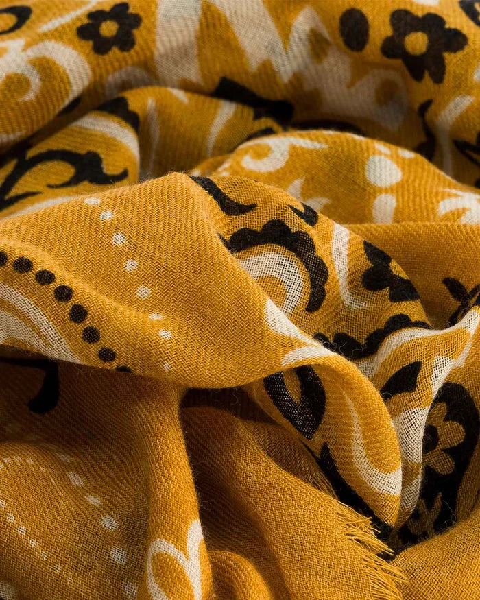 Close-up of a yellow fabric with black and white floral patterns