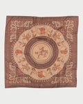 The Maison Lecomte Flament Rodeo Scarf Capuccino is a brown cotton voile scarf featuring a central cowboy on horseback, western motifs like boots, hats, saddles, horseshoes, and a paisley border.