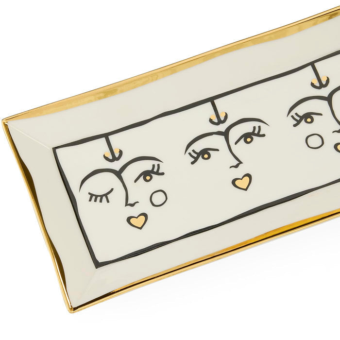 Decorative tray with abstract face designs and gold accents on a white background