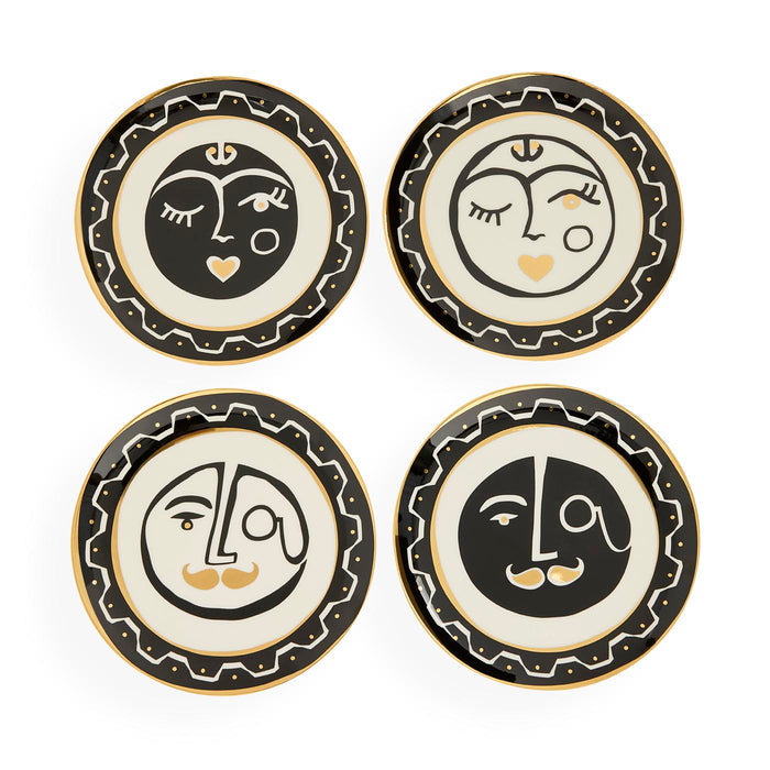 Four decorative plates with face designs on a white background