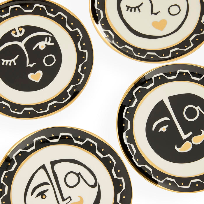 Set of decorative plates with abstract face designs on a white background
