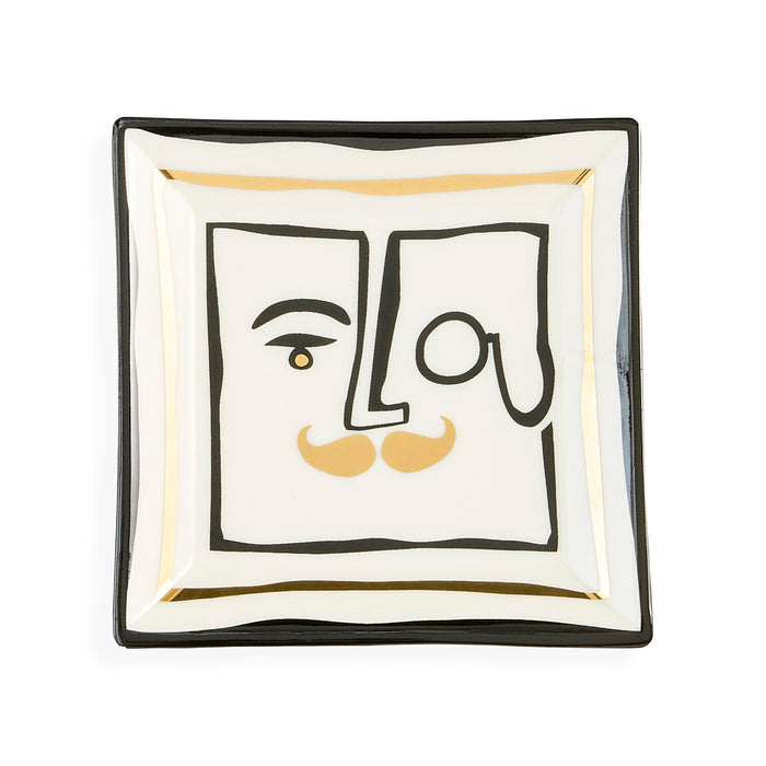 Square ceramic dish with abstract face design on a white background