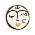 Decorative plate with a face design featuring a heart, on a white background
