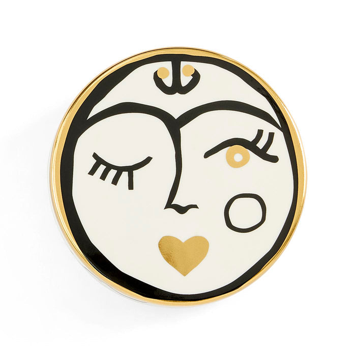Decorative plate with a face design featuring a heart, on a white background