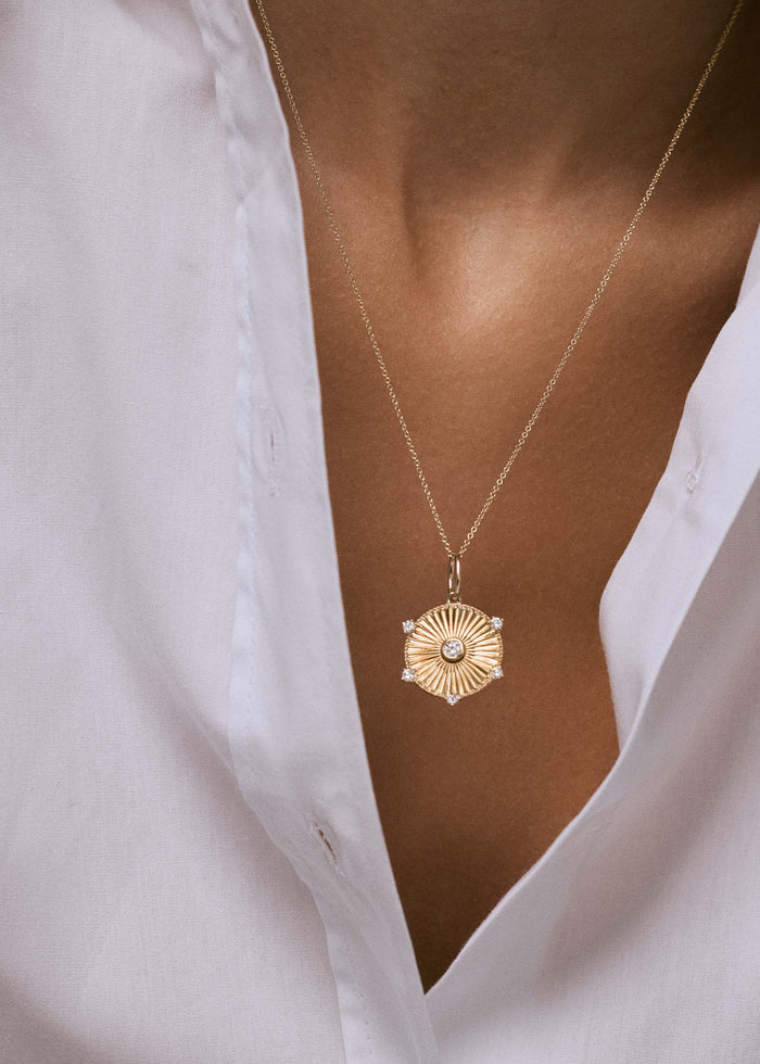 woman in a white shirt wearing a Kinn 14k Gold Jordyn Ribbed Coin Necklace Diamond on micro rolo chain