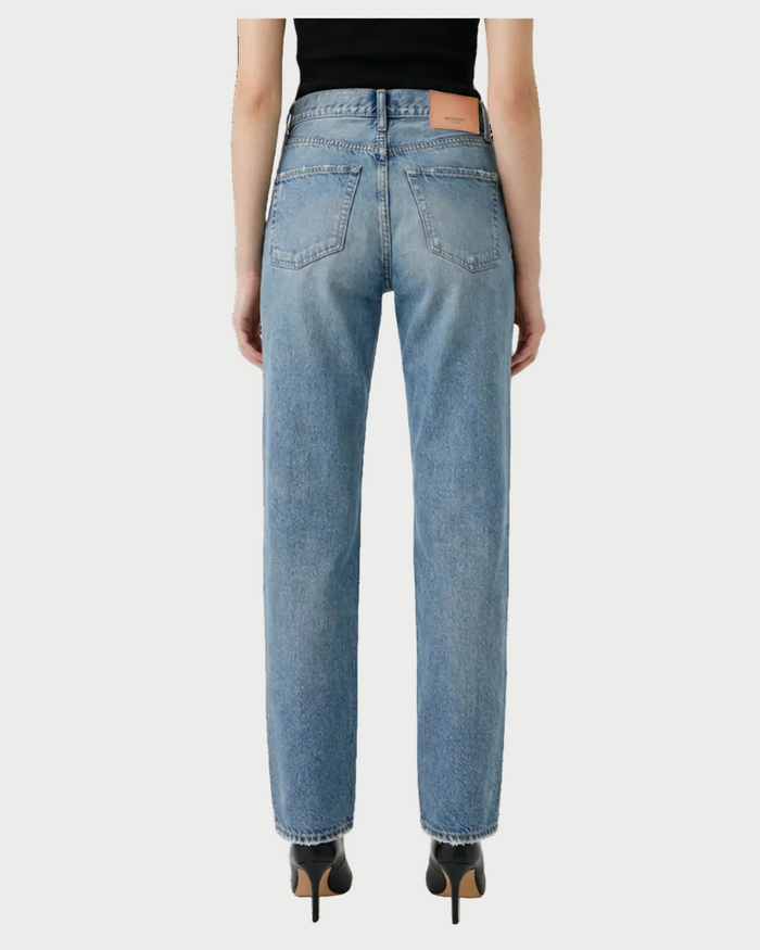 A person is seen from the back wearing Moussy Leyden Straight Jeans by Moussy, made from lightweight denim, paired with black heeled shoes and relaxed arms at their sides, set against a white background.
