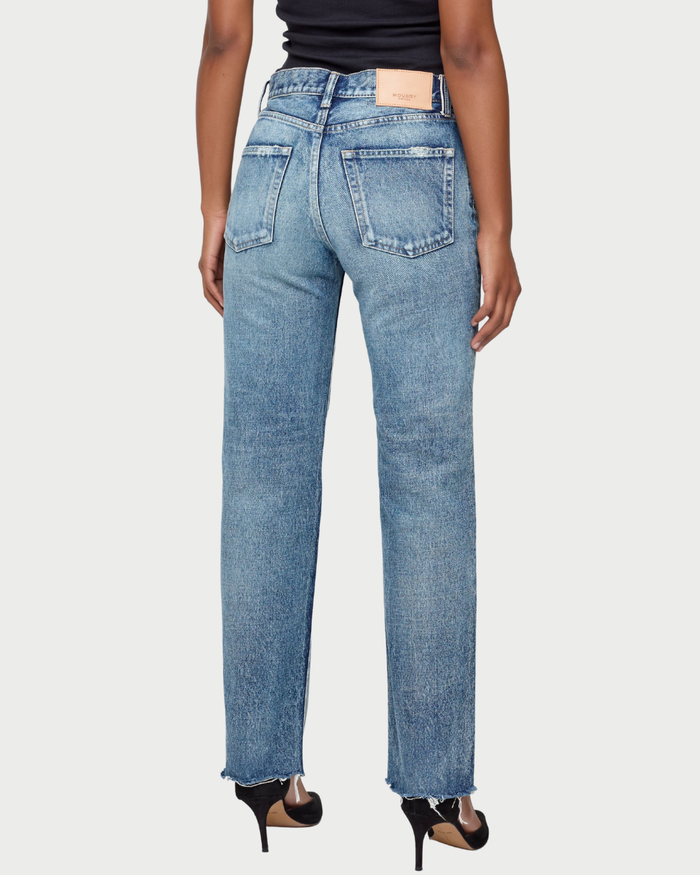 Blue jeans worn by a person on a white background