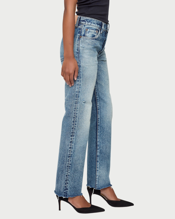 Person wearing light blue jeans on a white background