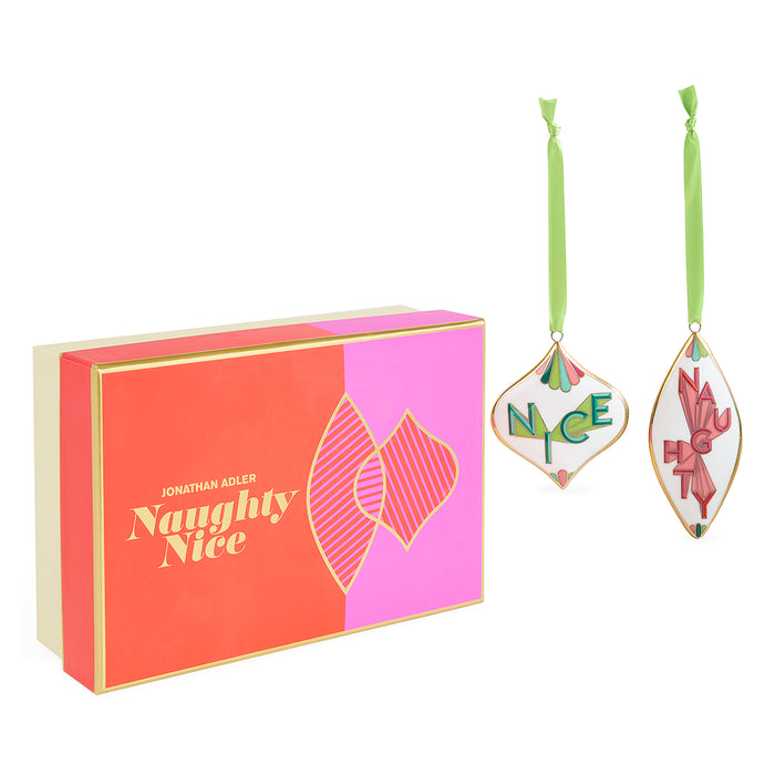 Jonathan Adler Naughty Nice Christmas ornament set with a red and pink gift box and two hanging ornaments on a white background.