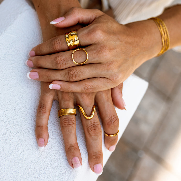 hands featuring an everyday gold ring stack featuring classy gold rings with unique melted gold designs