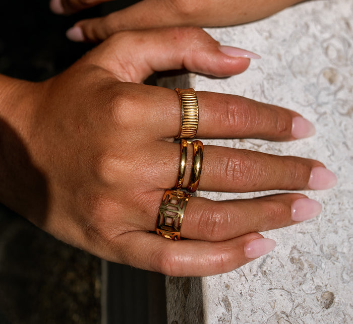 gold ring stack featuring three gold rings on a person
