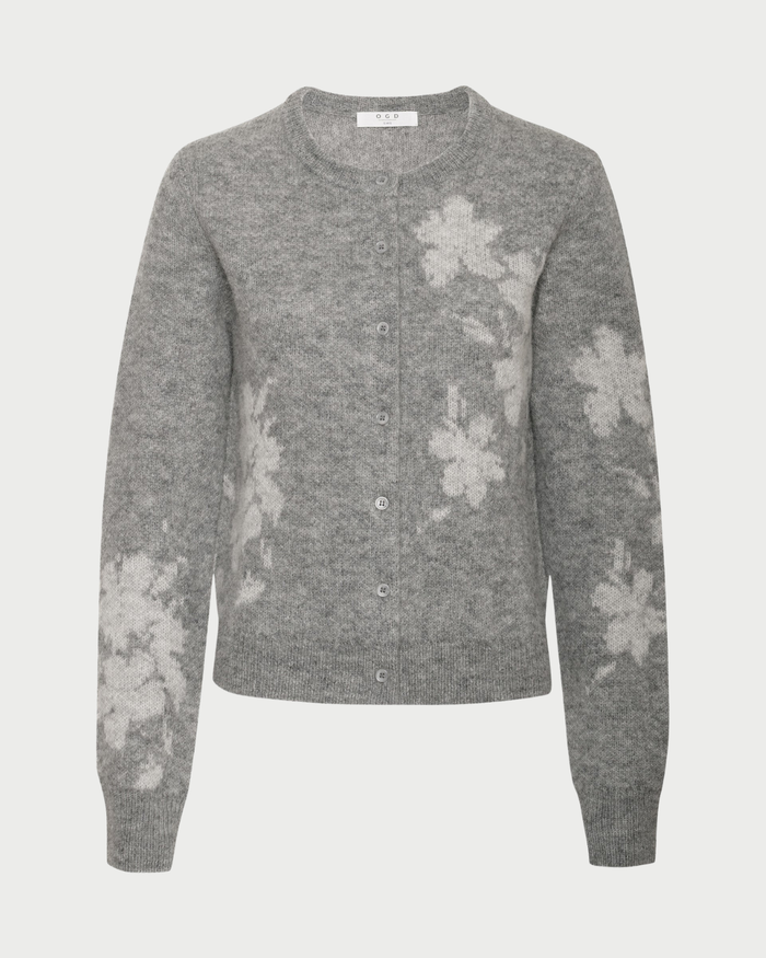The One Grey Day Mirelle Cardigan by One Grey Day features a grey base adorned with white floral patterns. Designed with long sleeves, a crew neckline, and a button-front closure, this relaxed fit cardigan offers a soft, cozy texture for effortless comfort and style.