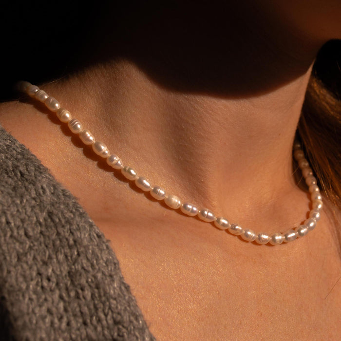 unique pearl necklace in direct sunlight on a neck